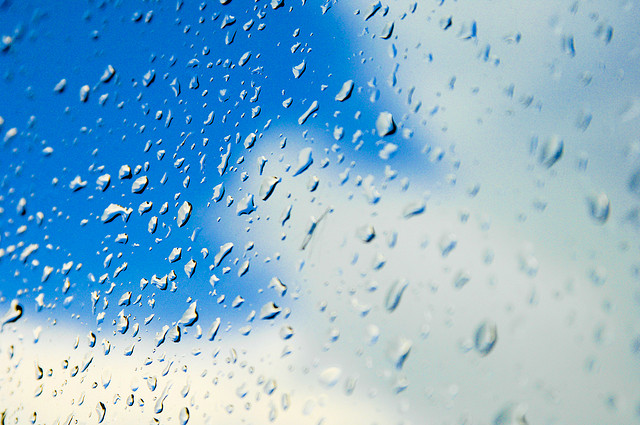 mixed weather blue sky and rain on glass window